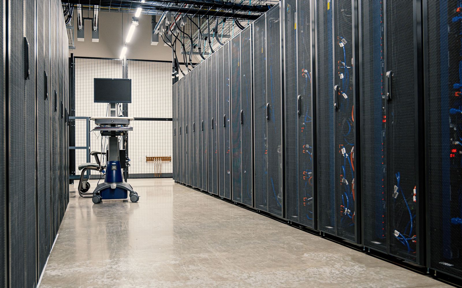 A bright data-centre aisle between rows of server racks