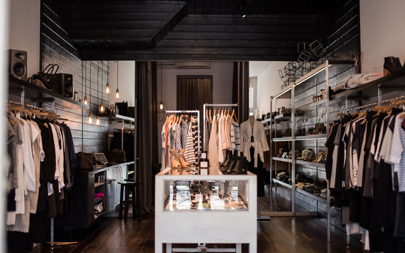 A premium clothing boutique with garments on rails and a glass display counter
