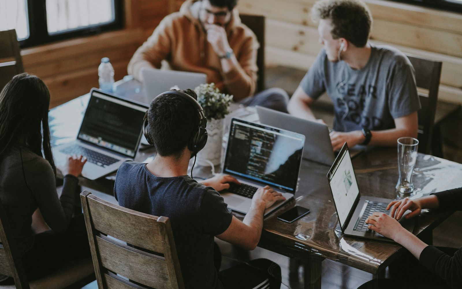 Developers working together at laptops around a wooden table